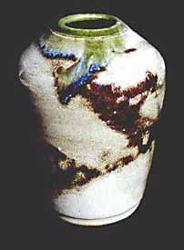 Wheel thrown porcelain vase with touches of iron oxide and celadon glaze.